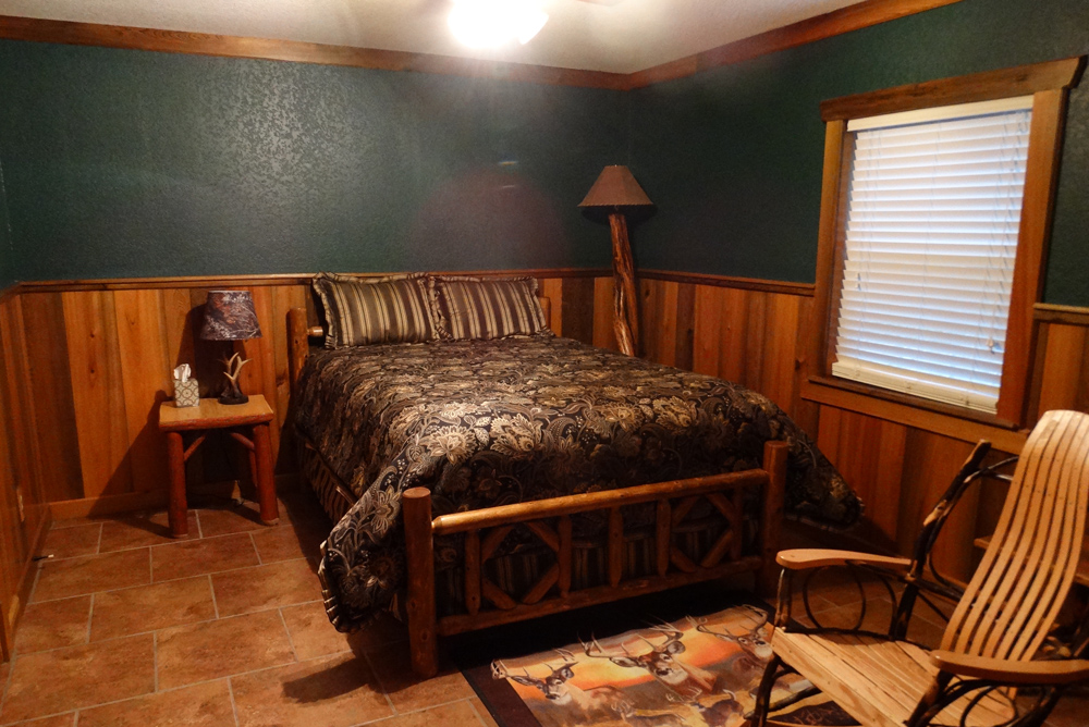 Green bedroom with queen size bed and rocking chair