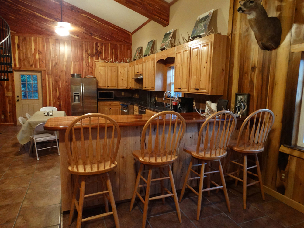 View of large kitchen with 4 bar stools