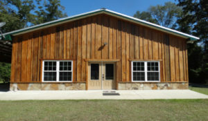 Front view of lodge with two sets of windows and double glass doors.