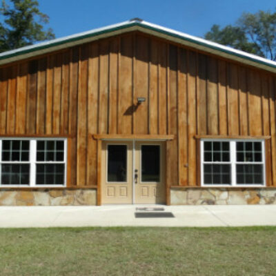 Front view of lodge with two sets of windows and double glass doors.